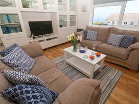 A living room with two sofas, a coffee table, and a television at Atlantic Waves in Carbis Bay