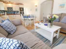 A living room with a dining area and kitchen at Atlantic Waves in Carbis Bay