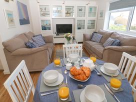 A living room with a sofa and table set in Atlantic Waves, Carbis Bay