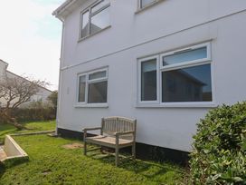 A garden area with a bench and windows at Atlantic Waves in Carbis Bay