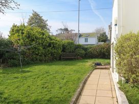 A garden with a pathway and bench at Atlantic Waves in Carbis Bay