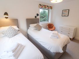 A bedroom with twin beds and a dresser at Bayside in Carbis Bay