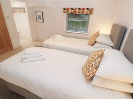 A bedroom with two beds and a wardrobe at Bayside in Carbis Bay