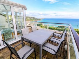 An outdoor terrace with a table and chairs at Ocean Gem in Carbis Bay