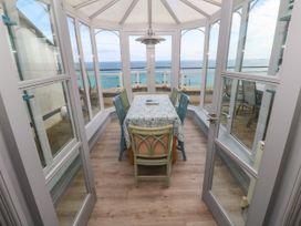 A conservatory with a table and chairs at Ocean Gem in Carbis Bay