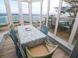 A conservatory with a dining table and chairs at Ocean Gem in Carbis Bay