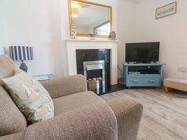 A living room with a television and a sofa at Ocean Gem in Carbis Bay