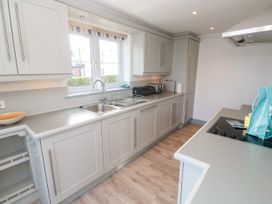 A kitchen with cabinets, sink, and countertop at Ocean Gem in Carbis Bay