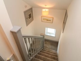 A stairwell with a window and art on the wall at Ocean Gem in Carbis Bay
