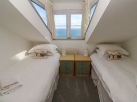 A bedroom with two beds and a view of the sea at Ocean Gem in Carbis Bay