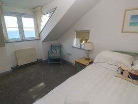 A bedroom with a bed and windows overlooking the sea at Ocean Gem, Carbis Bay