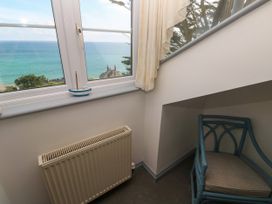 A corner with a chair and a radiator overlooking the sea at Ocean Gem in Carbis Bay