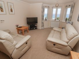 A living room with a sofa and television at Golva in Carbis Bay