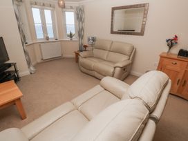 A living room with a sofa and television at Golva in Carbis Bay