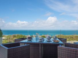 An outdoor dining area with a table set for tea at Halcyon Cove in Carbis Bay