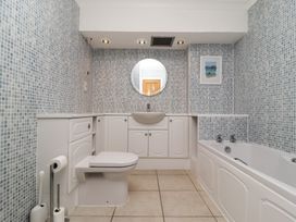 A bathroom with a toilet sink bathtub and tiled walls at Harbour View in Carbis Bay