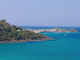 A coastal town with buildings near the sea and boats on the water at Harbour View in Carbis Bay