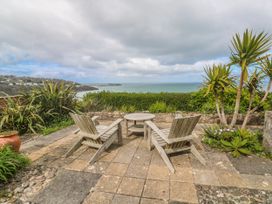 A patio area with chairs and a table overlooking the sea at Island View in Carbis Bay