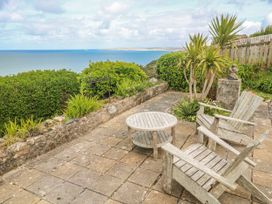 An outdoor seating area with wooden furniture and a sea view at Island View in Carbis Bay