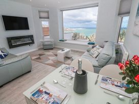 A living room with a sofa and dining table at Island View in Carbis Bay