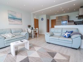A living room with sofas and a dining table at Island View in Carbis Bay