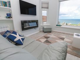 A living room with a television and a seaside view at Island View in Carbis Bay