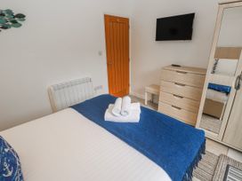 A bedroom with a bed, television, and dresser at Island View in Carbis Bay