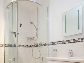A bathroom with a shower and mirror at Kittiwake in Carbis Bay