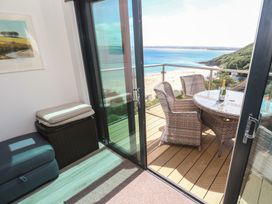 A balcony with a table and chairs at Oceania in St Ives