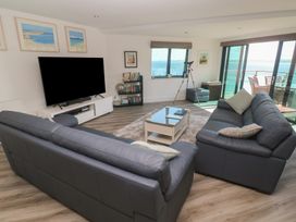 A living room with a television and sofas at Oceania in St Ives