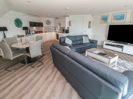 A living room with a sofa and dining table at Oceania St Ives
