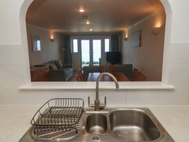 A kitchen with a sink and view into a living area at Sapphire in Carbis Bay