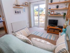 A living room with a sofa and television at Sea Breeze in Carbis Bay