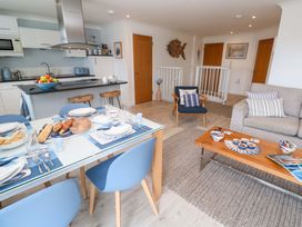 A dining area with table and chairs and a living space at Sea Breeze in Carbis Bay