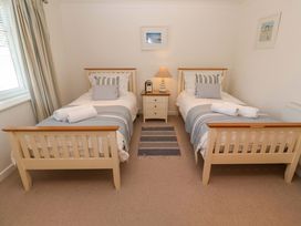A bedroom with two beds and a side table at Sea Breeze in Carbis Bay