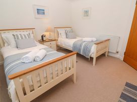 A bedroom with two beds and a nightstand at Sea Breeze in Carbis Bay