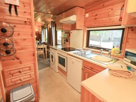 A kitchen with various appliances and a dining area at Squirrels Leap, Number 29, Burnside Park near Keswick