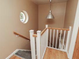 A staircase with a handrail and round window at ASTA COTTAGE Cresswell