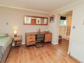 A bedroom with a bed, desk, and mirror at ASTA COTTAGE in Cresswell