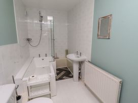 A bathroom with a bathtub, shower, toilet and sink at ASTA COTTAGE in Cresswell