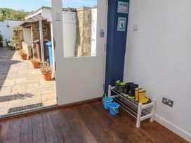An entryway with boots on a rack at ASTA COTTAGE in Cresswell