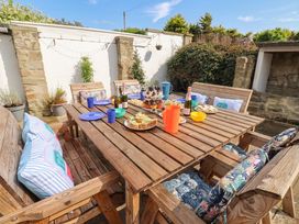 A garden dining setup with food and drinks at ASTA COTTAGE Cresswell