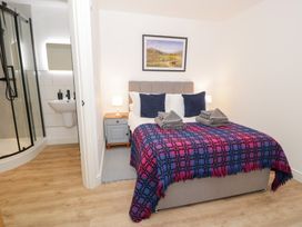 A bedroom with a bed and adjoining shower at Merddwr in Cerrigydrudion