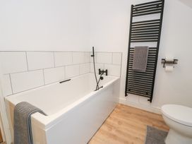 A bathroom featuring a bathtub, toilet, and towel rack at Merddwr in Cerrigydrudion