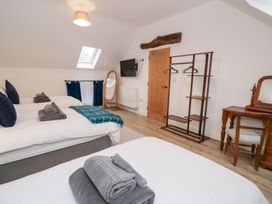 A bedroom with two beds and a mirror at Merddwr in Cerrigydrudion