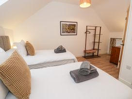 A bedroom with two beds and a chest of drawers at Merddwr in Cerrigydrudion