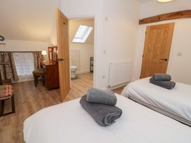 A bedroom with two beds and a dresser at Merddwr in Cerrigydrudion
