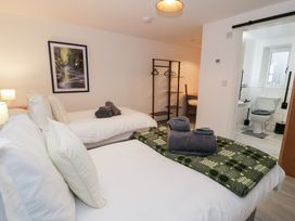 A bedroom with two beds and an adjoining bathroom at Merddwr in Cerrigydrudion