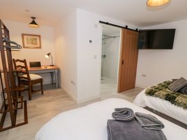 A bedroom with a bed, desk and chair at Merddwr in Cerrigydrudion