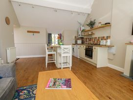 A kitchen with seating and appliances at Sea Pink Cottage in Langton Matravers